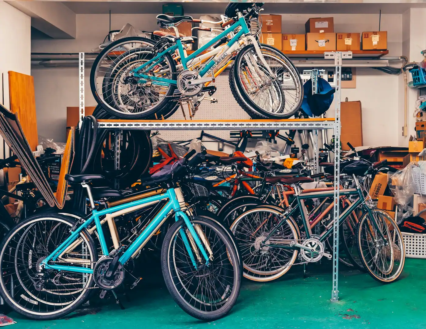 Several bicycles stored on metal shelving and the floor of a bright, organized garage